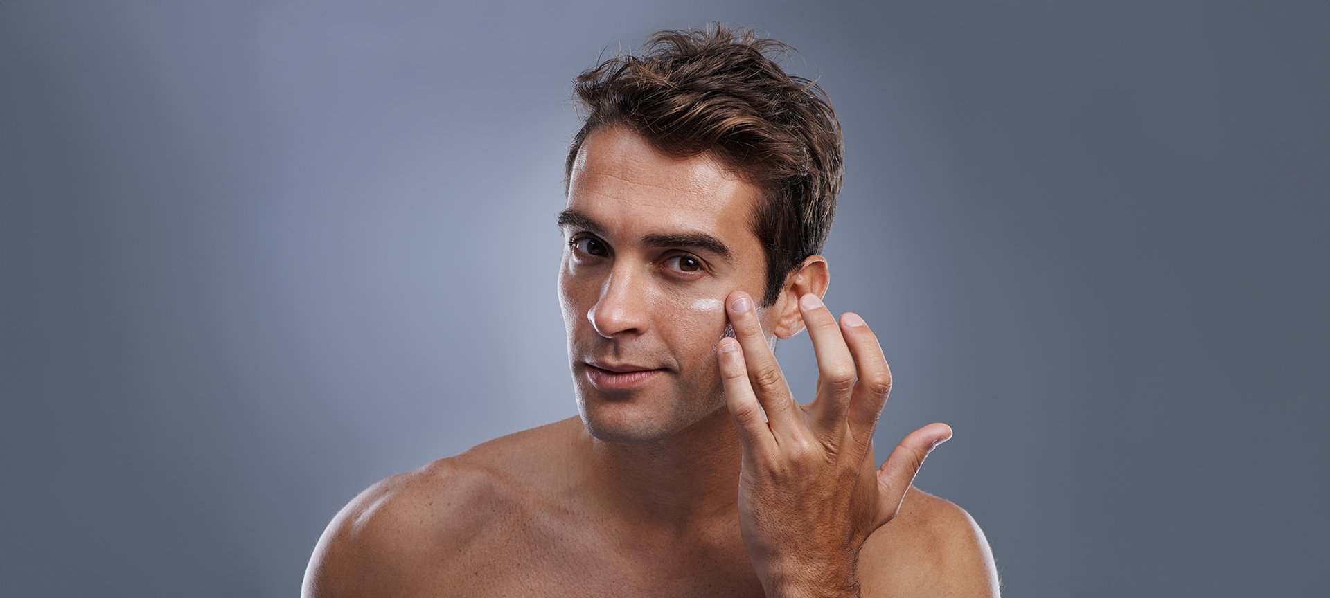 mężczyzna nakładający krem na twarz