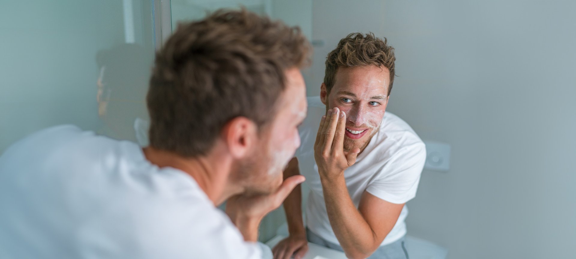 mężczyzna nakładający krem na twarz