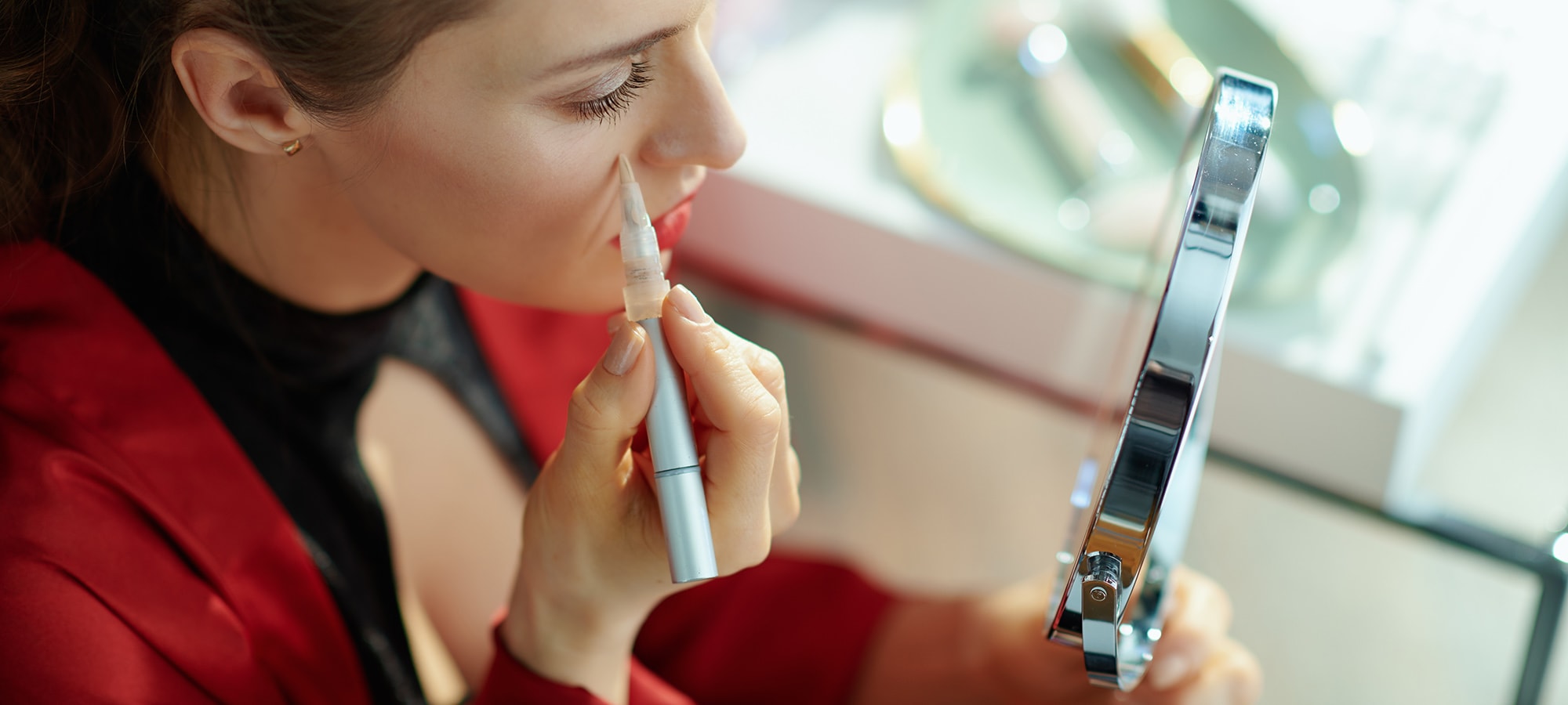 Kobieta wykonuje makijaż i używa korektora pod oczy 