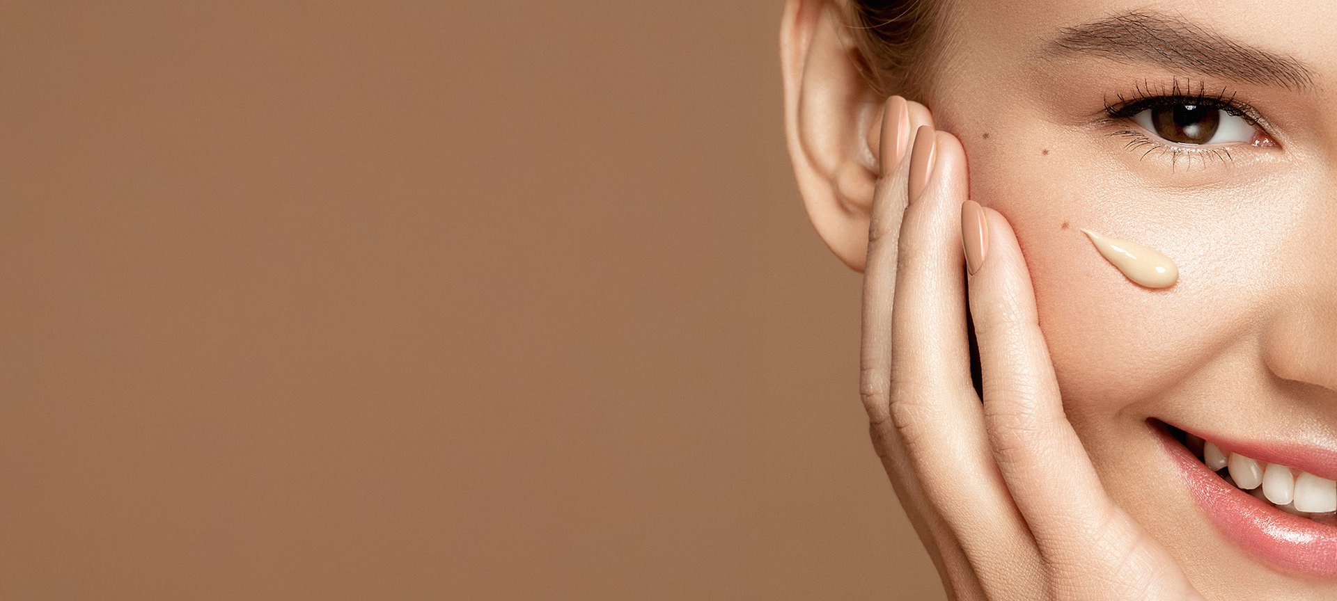 Uśmiechnięta kobieta z nałożonym kremem BB na twarzy