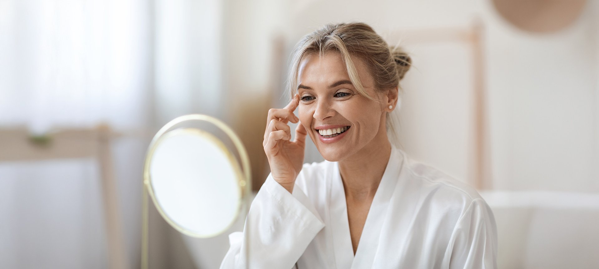 kobieta w średnim wieku nakładająca krem przeciwzmarszczkowy