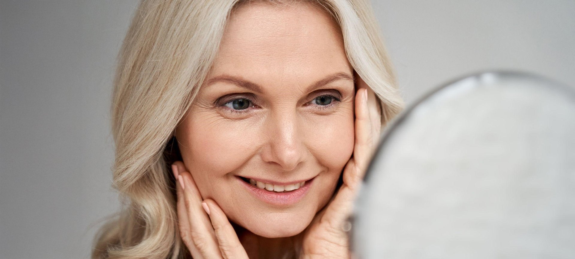 Kobieta podziwiająca swój makijaż w lustrze