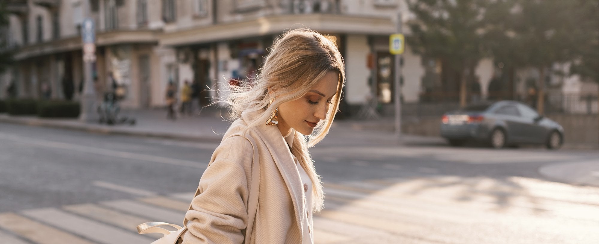 Kobieta w ciepłym odcieniu blond spaceruje po mieście