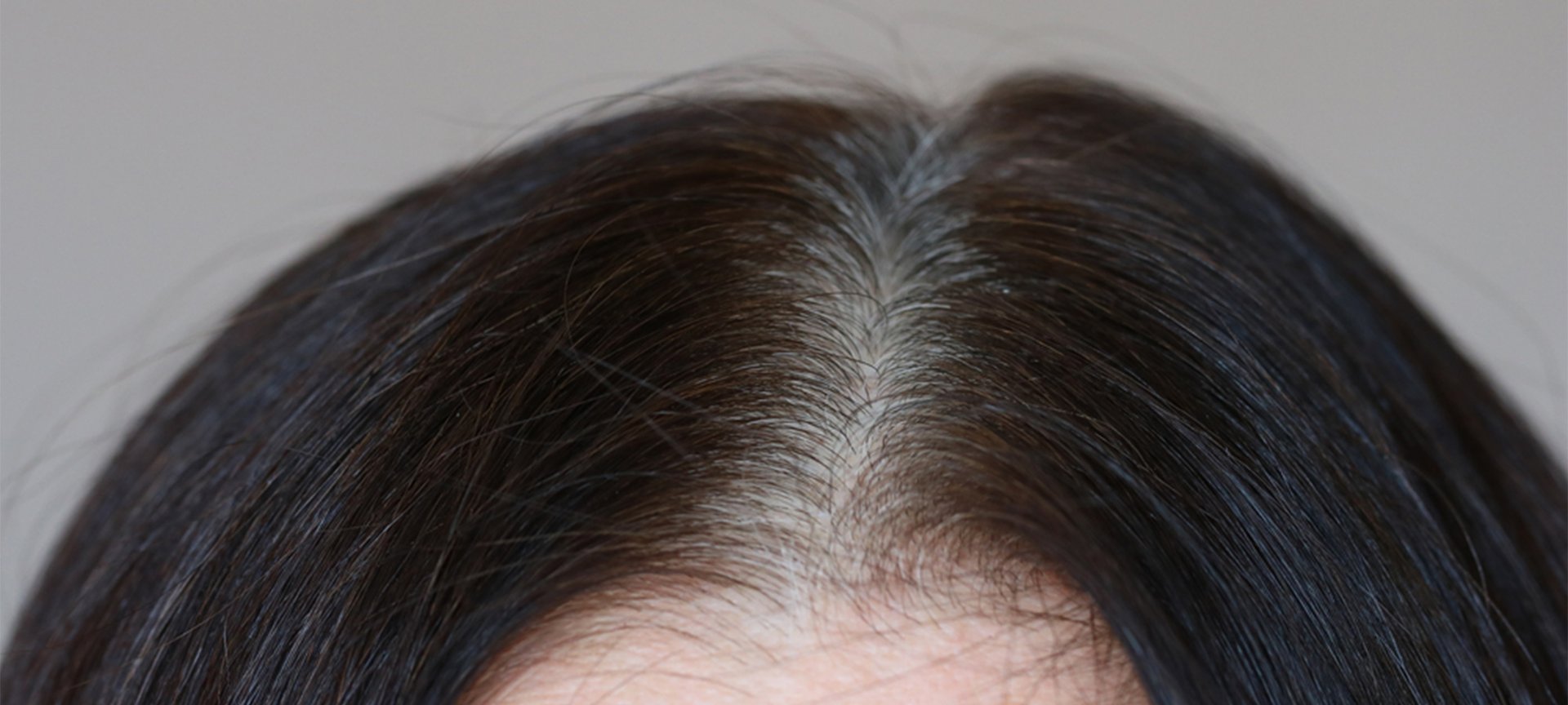 Przykład siwych odrostów na ciemnych włosach