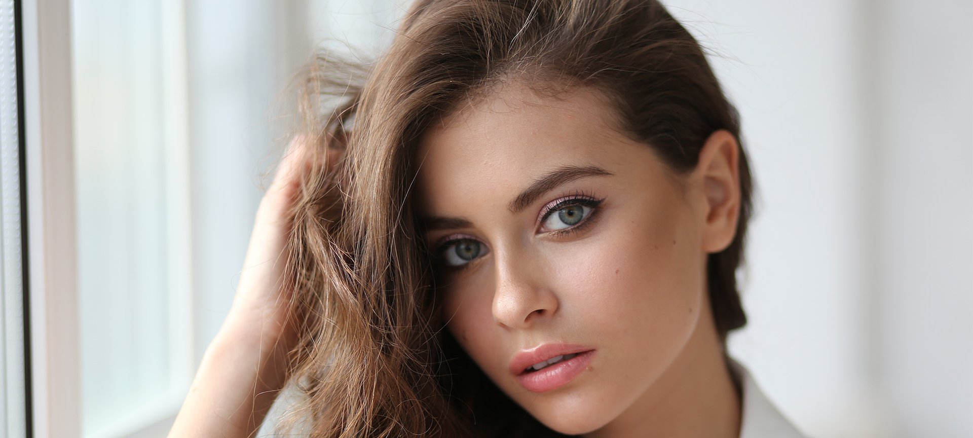 Brunetka w kolorze jasnego brązu patrzy w obiektyw aparatu