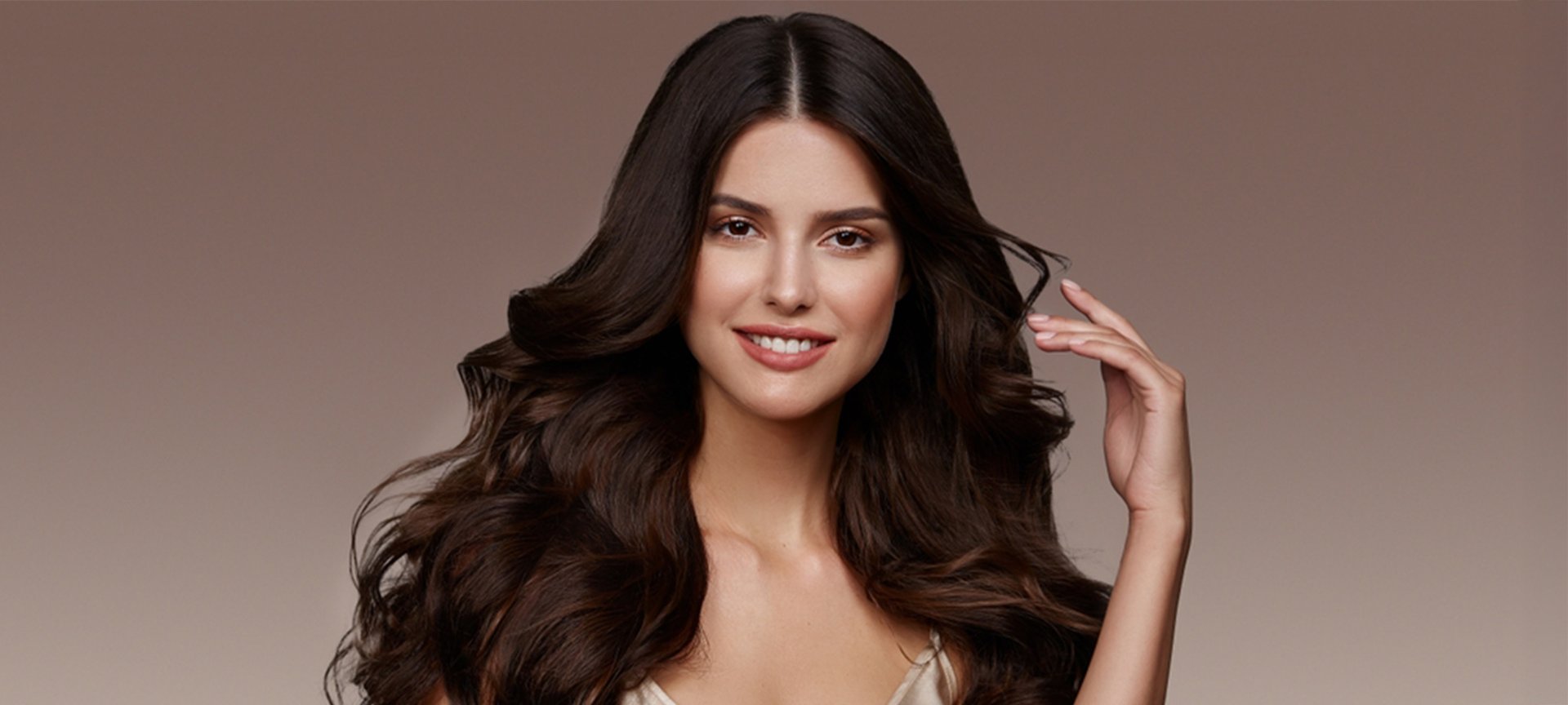 Kobieta o długich, falowanych brązowych włosach