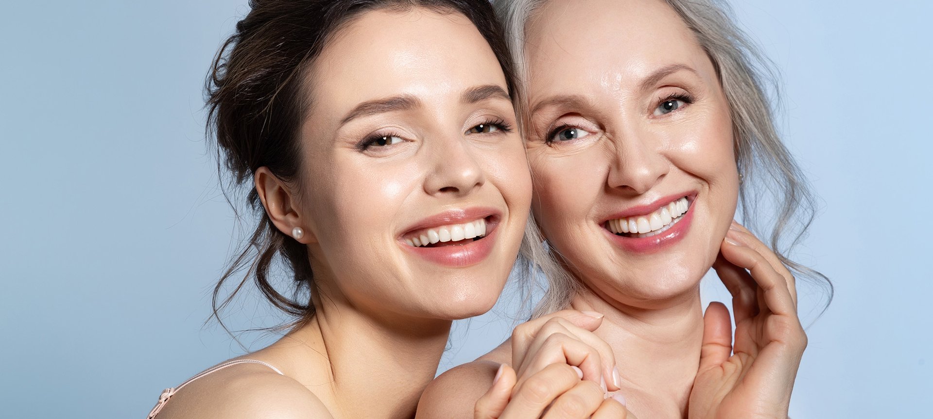 matka z córką o świetlistej cerze uśmiechające się w stronę obiektywu