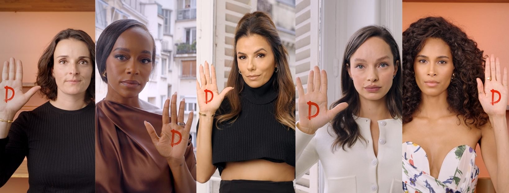 kobiety z podniesionymi rękoma i namalowaną literą D na dłoni