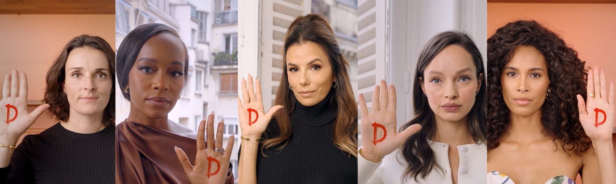 kobiety z podniesionymi rękoma i namalowaną literą D na dłoni
